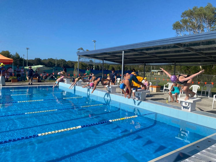 Students diving of the blocks into the pool at the school Swimming Carnival