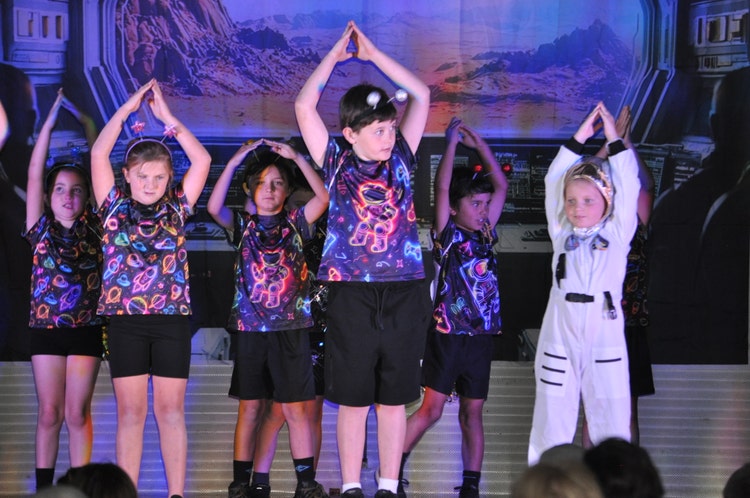 students performing on stage at our Whole School Performance Lost in Space