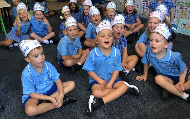 Kindy students sitting on the floor singing