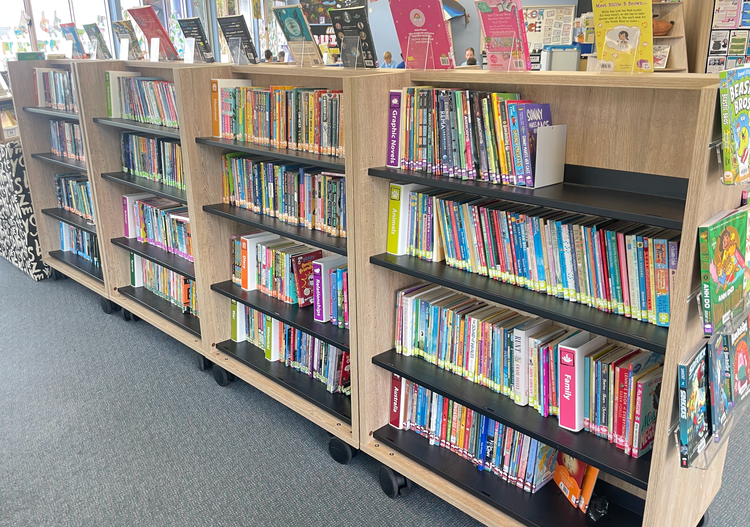 Senior fiction books on a shelf with spine out organised in genres