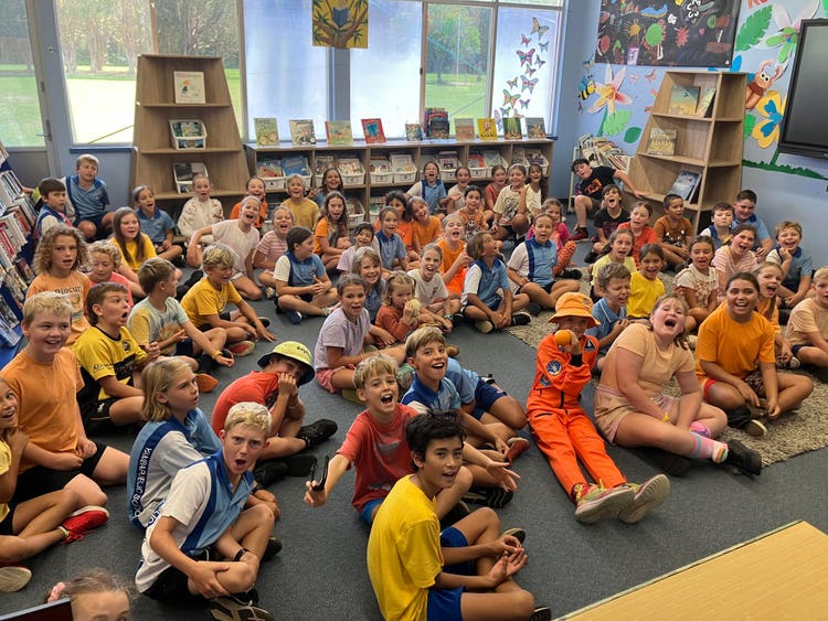students all sitting on floor singing on Harmony Day