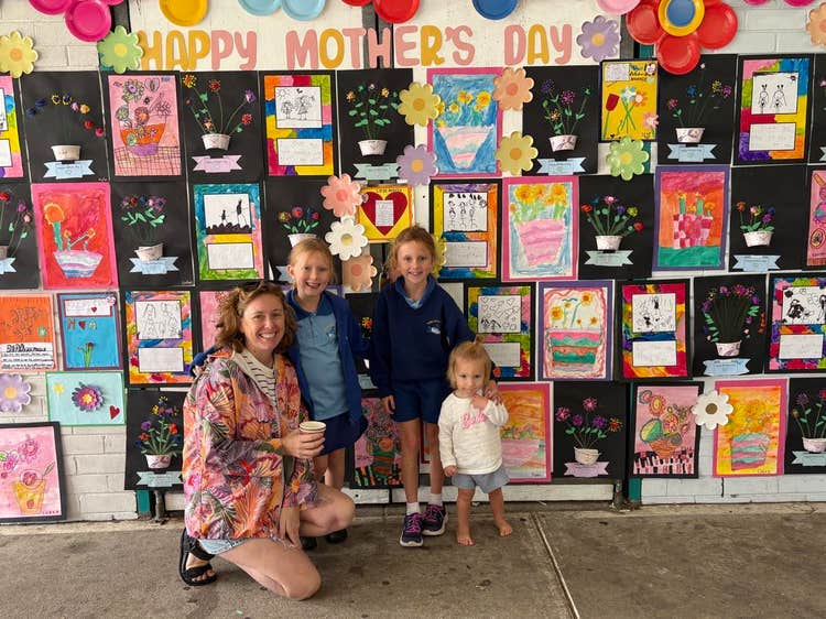 Photo of Mum and three children in front of our Mothers Day wall