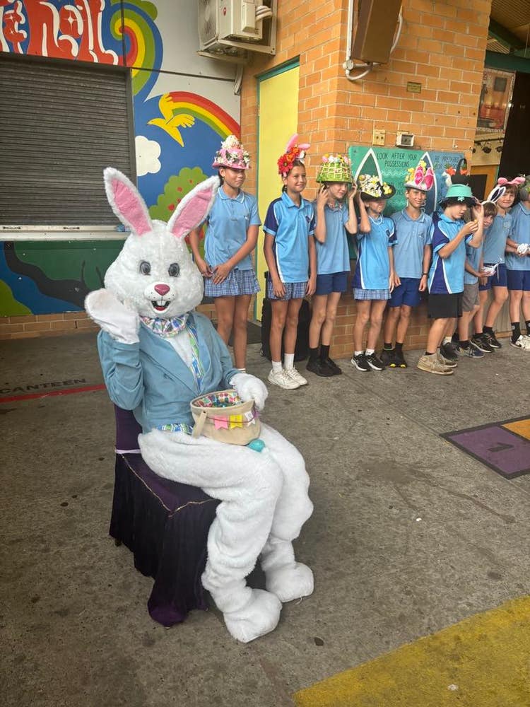 Easter Bunny sitting on a chair and students with the Easter hats