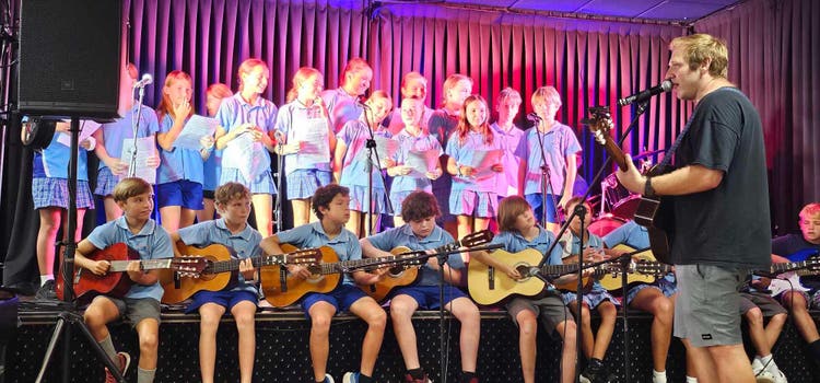 students performing with guitars and singing at the Cane Harvest Festival