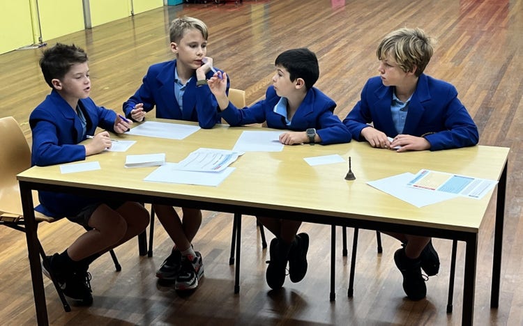 four students at table in debating competition