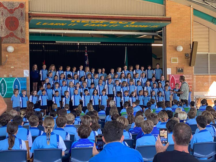 students sitting and standing at assembly