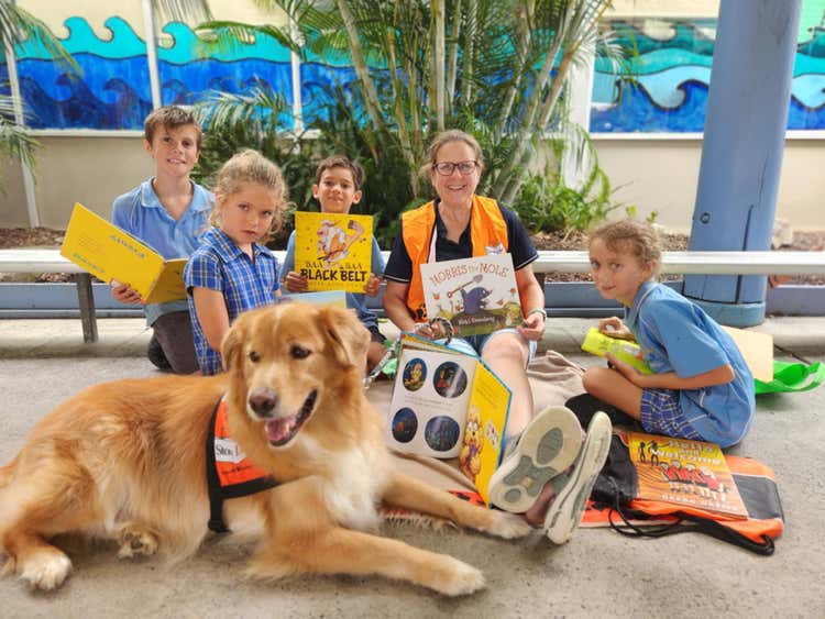 five students sitting with books with storey dog