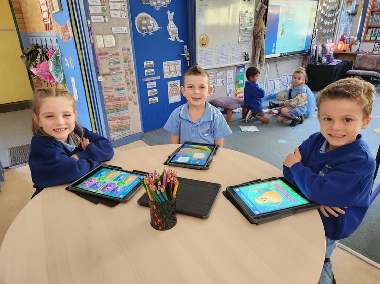 three students with tablets learning