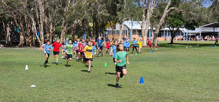Students running on sports field in a race
