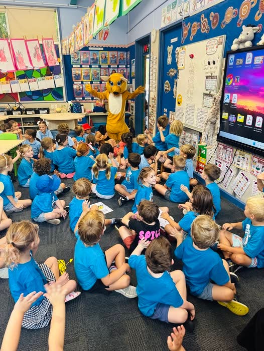 Clarry the school mascot waving to the Kindy O students